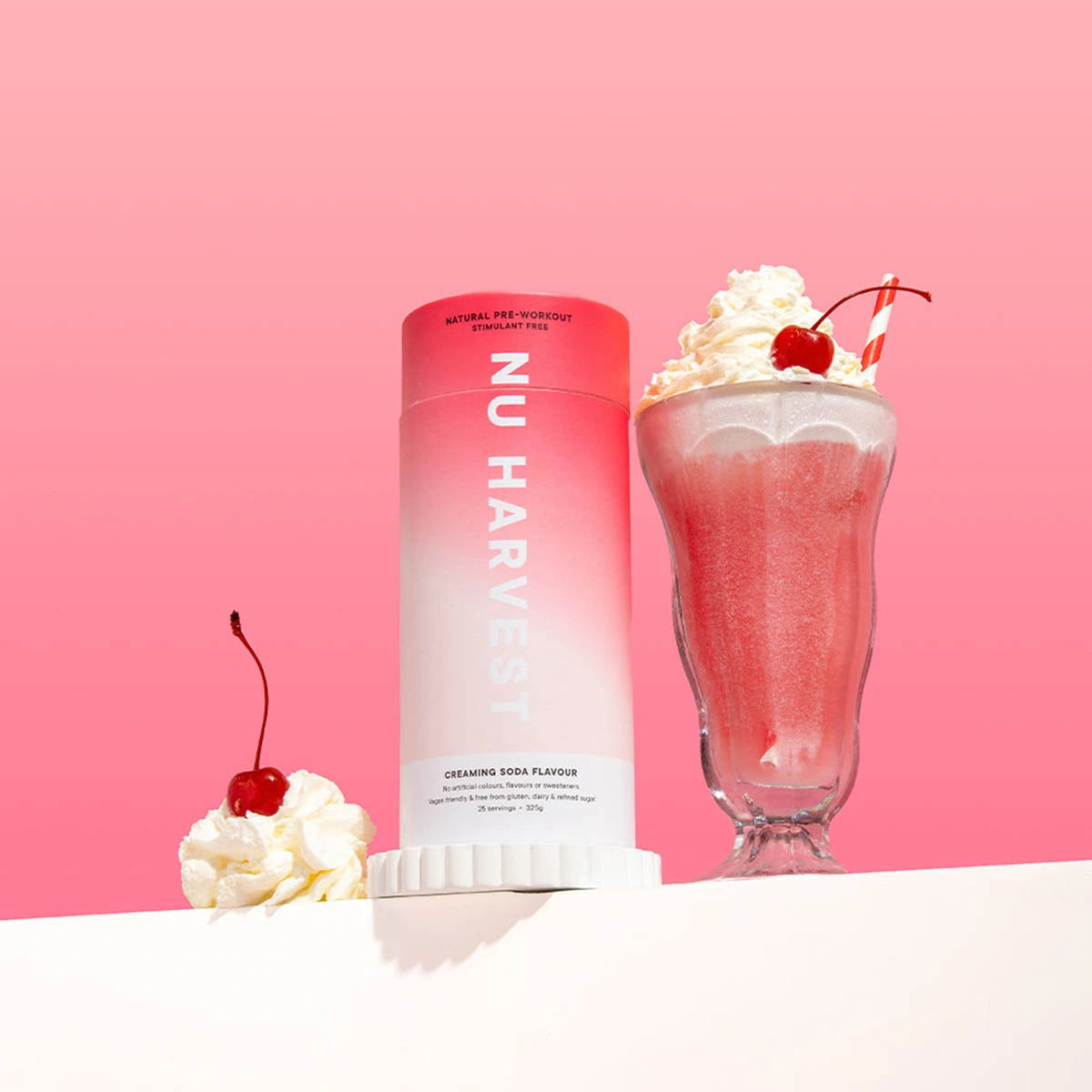 NU HARVEST product with a pink gradient bottle, whipped cream, and cherry on a pink background