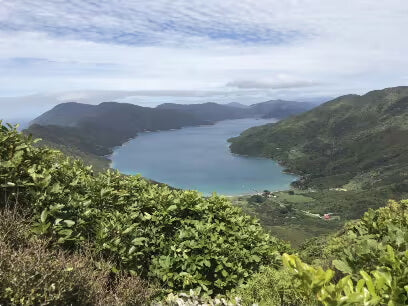 green mountains surrounding large blue lake