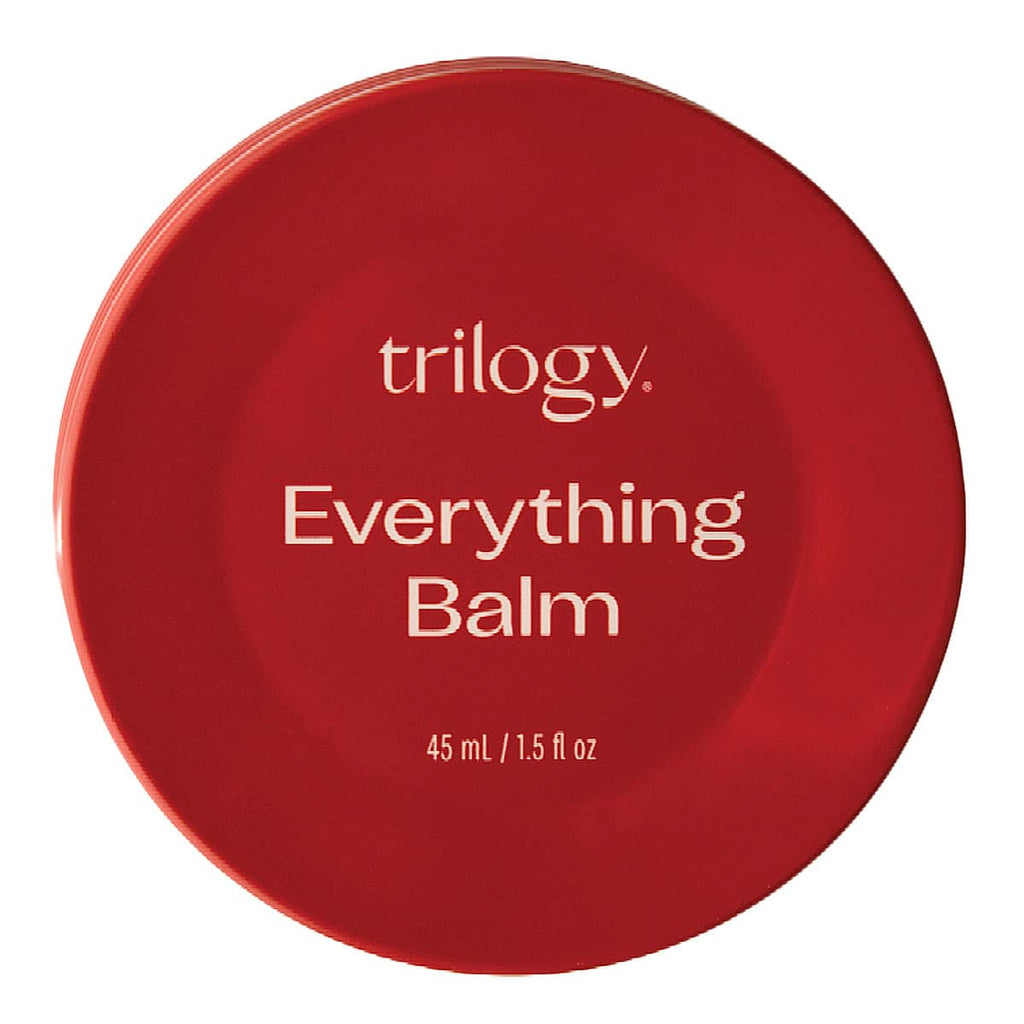 Red container of Trilogy Everything Balm on a white background.